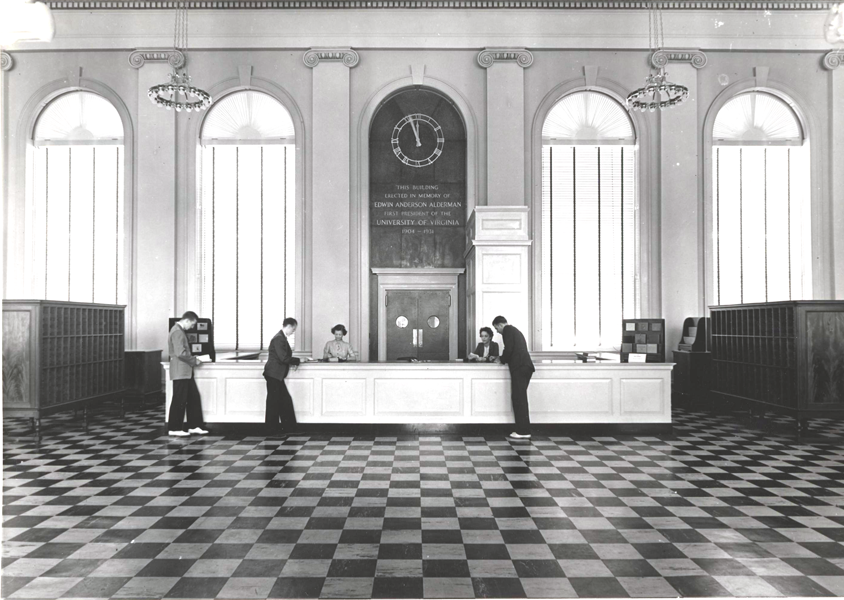 1938 -  The new library is completed at a cost of $950,909. Designed to accommodate 100 staff members, 1000 readers, and 600,000 volumes, Alderman Library, named in memory of Edwin Alderman, was formally dedicated during Final Exercises in June 1938.

image: Alderman Library circulation desk in Memorial Hall, 1938.
